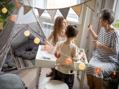 Mother explaining children early development sensory sandbox tasks preschool education playing game at home. Woman teacher assistant spending time with boy and girl elementary learning entertainment